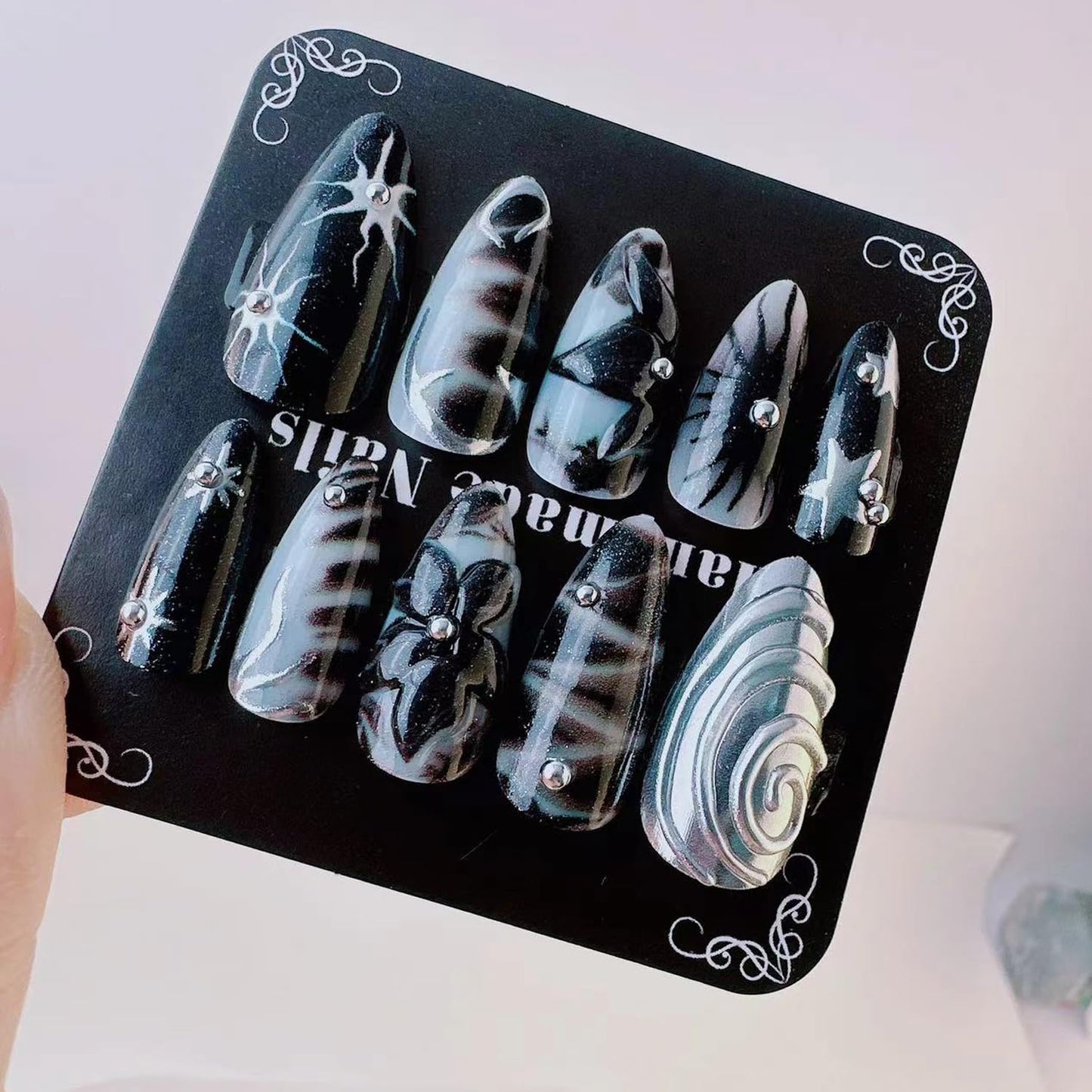 Y2K Gothic Press on Nails, Medium Almond 3D Black Silver Swirl Fake Nails with Embossed Flower & Star Designs, Metallic False Nails with Glue Tabs - 24Pcs Nail Kit for Women French Manicure